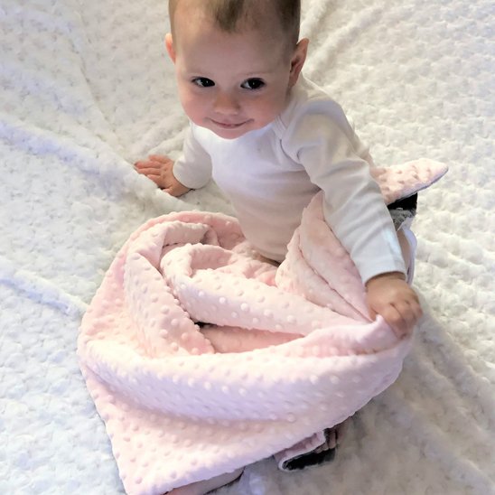 Bébé avec couverture douce rose