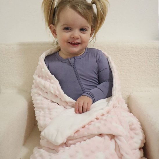 Enfant assis avec couverture bébé rose 