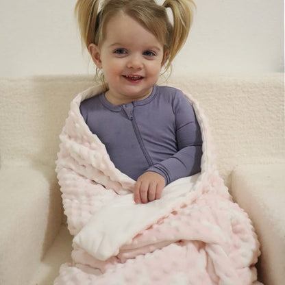 Enfant assis avec couverture bébé rose 