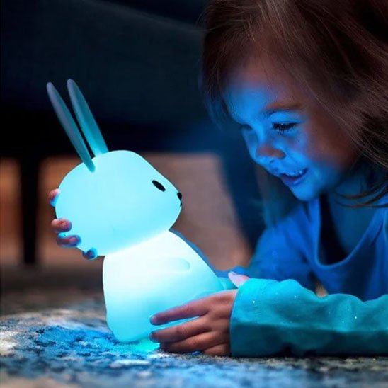 Enfant émerveiller avec veilleuse bébé lapin